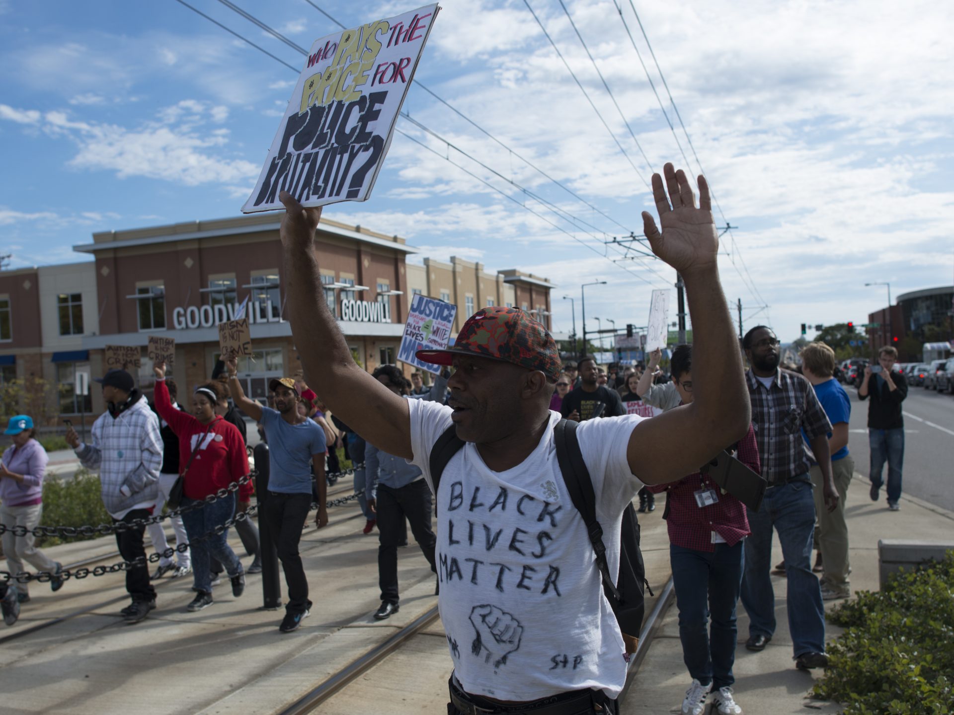 Black Lives Matter protestor with placard: Who pays the price for police brutality?