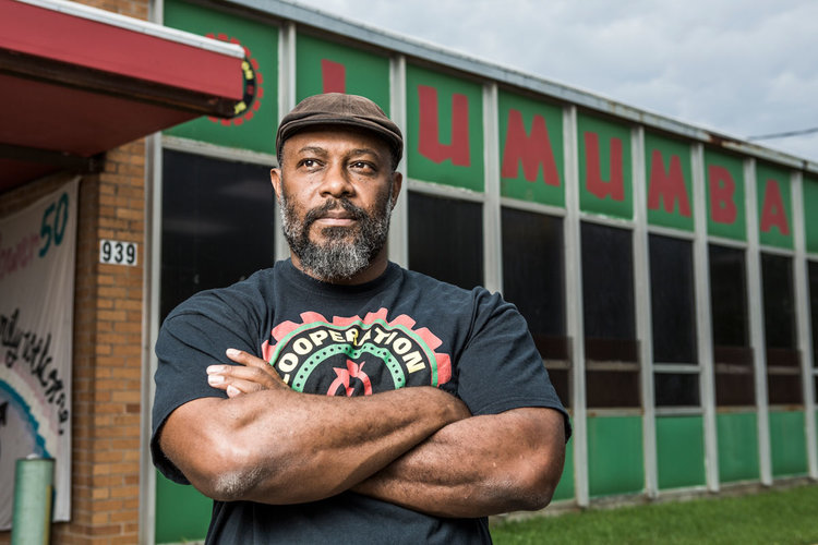 Kali Akuno in front of the Chokwe Lumumba Center for Economic Democracy and Development, where Cooperation Jackson is headquartered. Photo credit: Cooperation Jackson